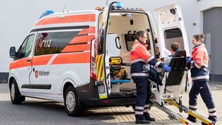 Zwei Rettungssanitäter der Malteser führen einen Krankentransport durch.