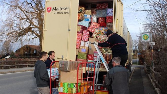 Malteser Helfer beladen den LKW für die Glücksbringer-Weihnachtshilfe für rumänische Bedürftige mit Paketen..